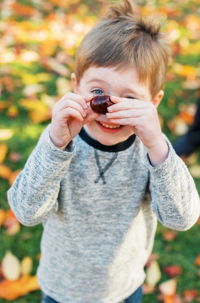 Jack Learning Hero Five year old boy holding chestnut and peering over it